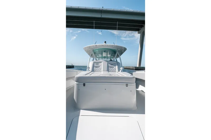 Slide: The Image of 2024 Contender 44 Fisharound boat under a bridge, showcasing sleek design and spacious deck. - 49