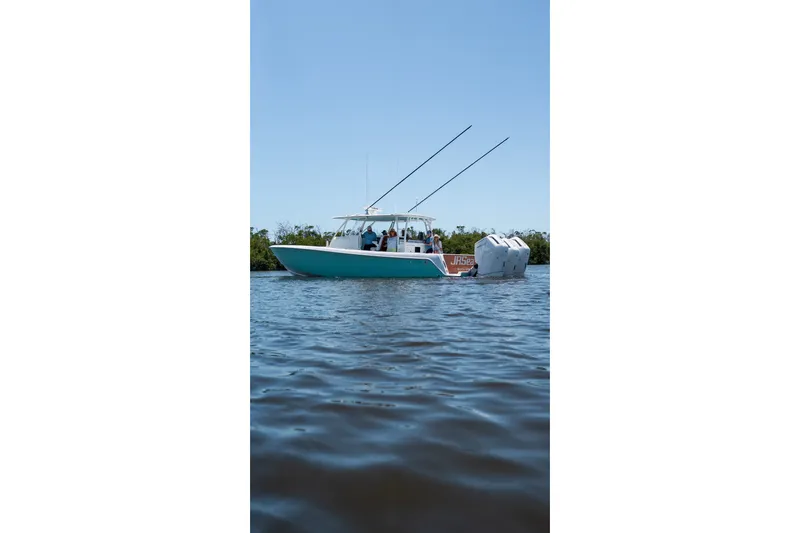 The Image of 2024 Contender 44 Fisharound boat on calm water, featuring dual outboard engines. - 0