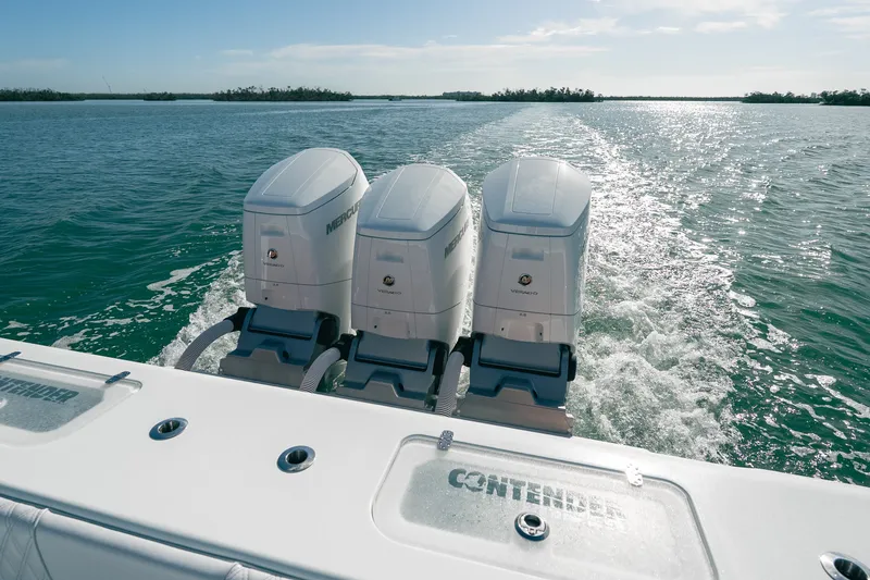 Slide: The Image of 2024 Contender 44 Fisharound with triple Mercury outboard engines cruising on open water. - 19