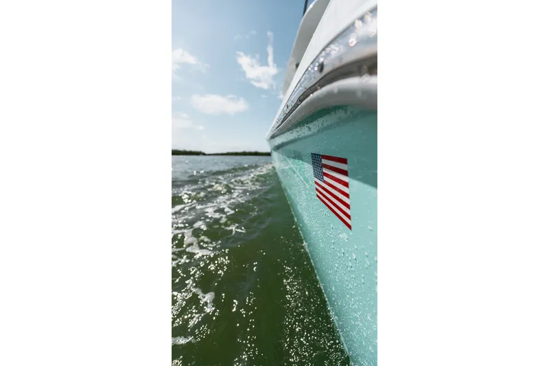 Slide: The Image of 2024 Contender 44 Fisharound boat cruising on water, featuring an American flag decal. - 56