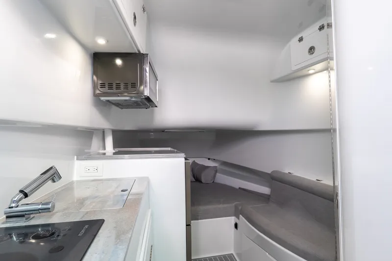 Slide: The Image of 2024 Contender 44 Fisharound cabin interior with modern kitchenette and cozy seating area. - 8