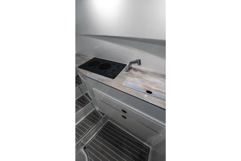 Slide: The Image of 2024 Contender 44 Fisharound interior kitchen with modern stovetop and sleek countertop design. - 69