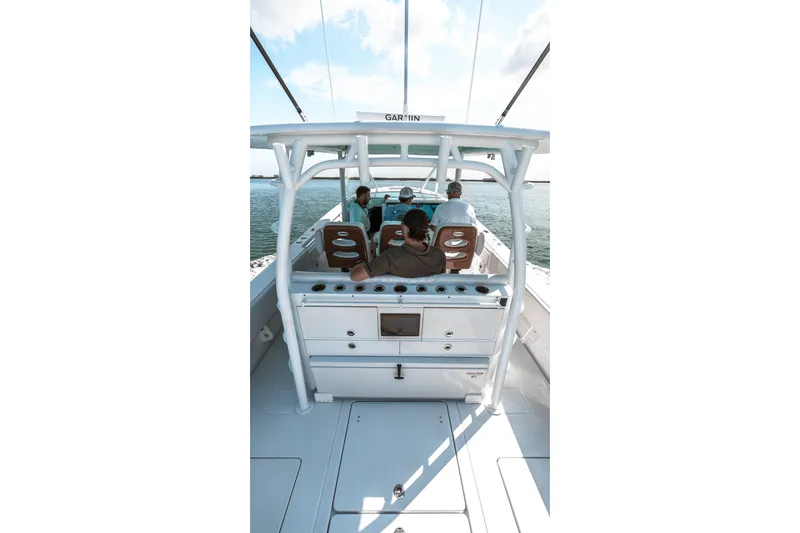Slide: The Image of 2024 Contender 44 Fisharound boat with passengers on deck, cruising on open water. - 50