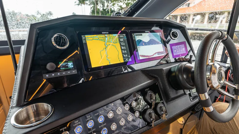 Slide: The Image of The image shows the dashboard of a 2027 Hanover 415 boat with modern navigation systems. - 27