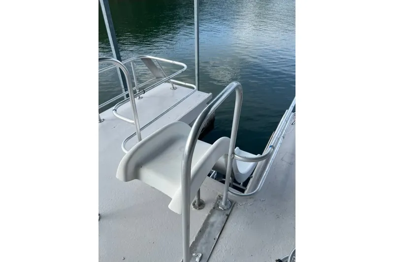 Slide: The Image of 1988 Stardust Cruisers 16x65 boat with a slide leading into the water. - 12