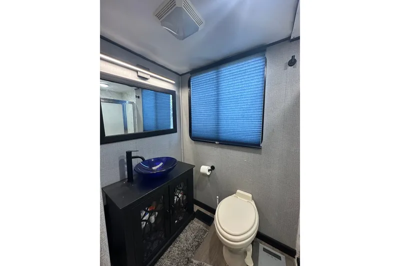 Slide: The Image of Bathroom interior of 1988 Stardust Cruisers 16x65 with modern sink and blue blinds. - 9