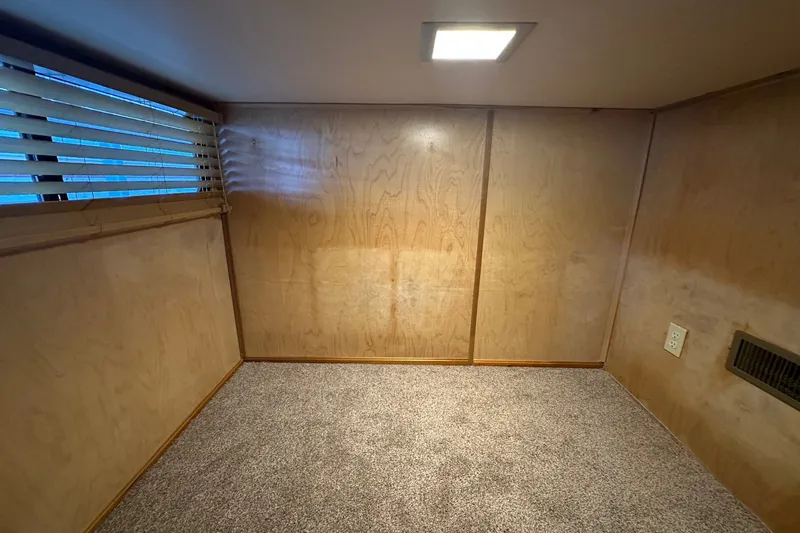 Slide: The Image of Interior of 1988 Stardust Cruisers 16x65, featuring wood paneling and carpeted flooring. - 8