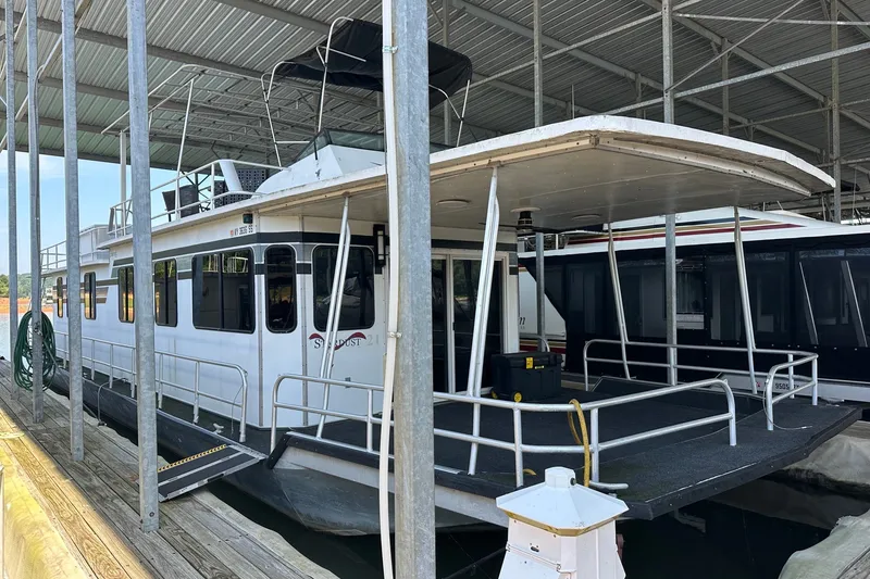 The Image of 1988 Stardust Cruisers 16x65 houseboat docked in a covered marina. - 0