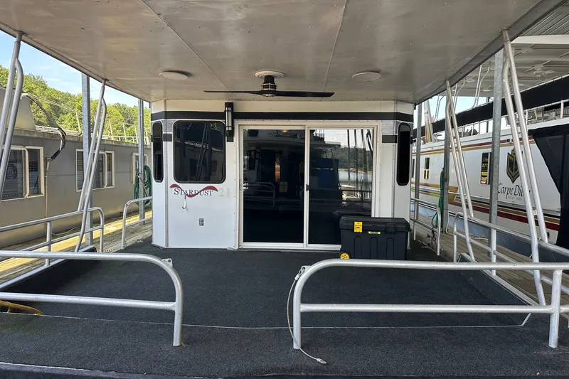 Slide: The Image of 1988 Stardust Cruisers 16x65 houseboat with spacious deck and sliding glass doors. - 1