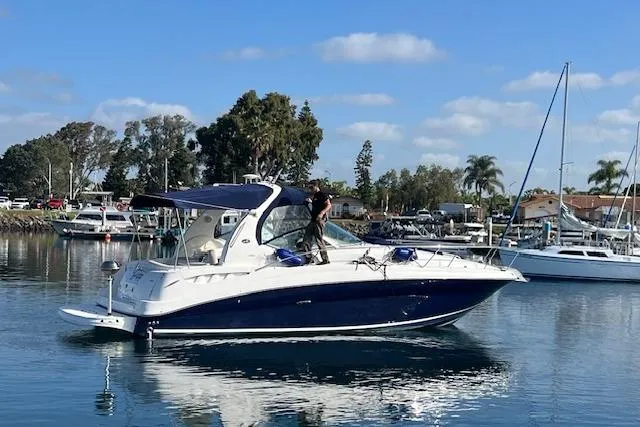 Slide: The Image of 2005 Searay 320 boat cruising in a marina under a clear blue sky. - 20
