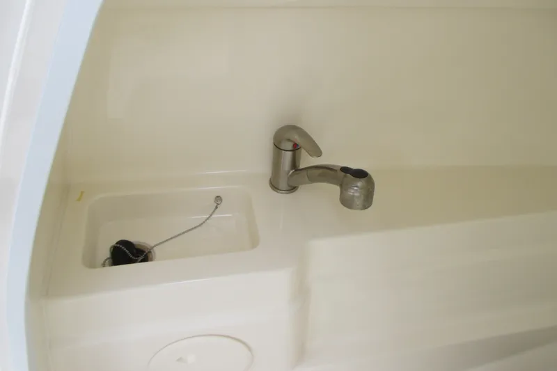Slide: The Image of Boston Whaler 230 Vantage 2013 boat sink with faucet and drain plug. - 12