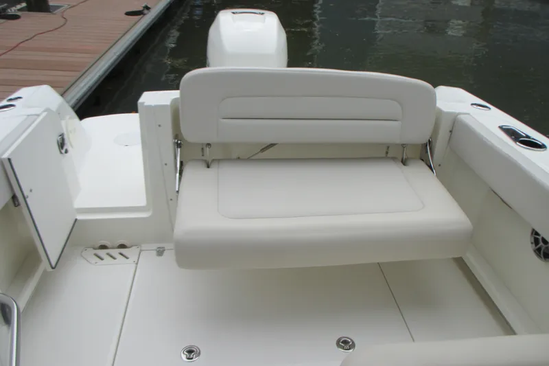 Slide: The Image of 2013 Boston Whaler 230 Vantage boat interior with white cushioned seating. - 8