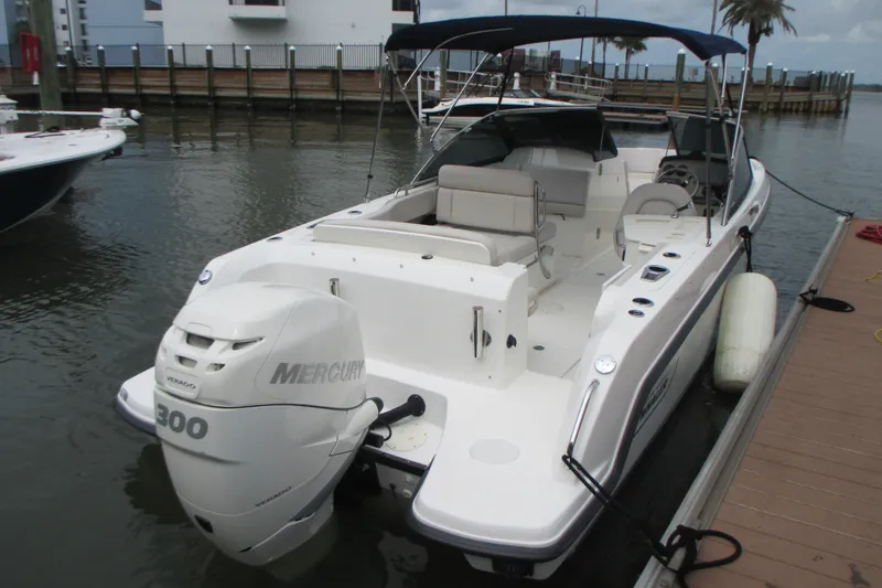 Slide: The Image of 2013 Boston Whaler 230 Vantage boat docked, featuring a Mercury 300 engine. - 5