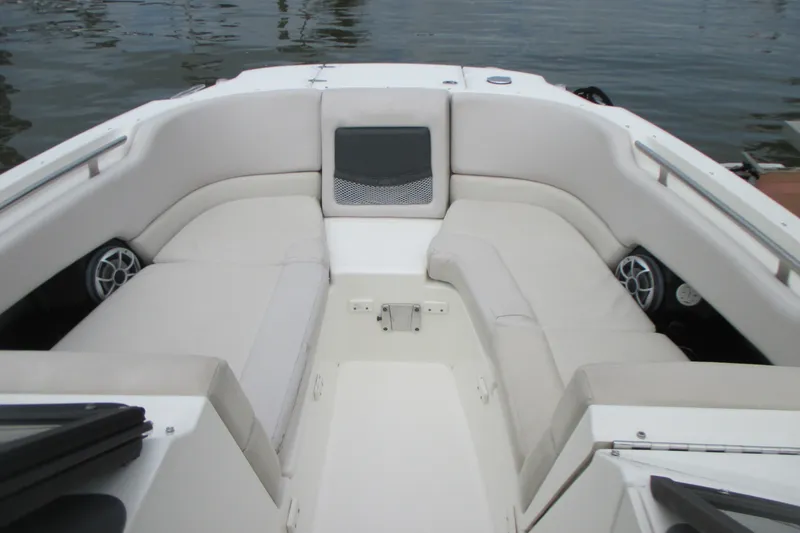 Slide: The Image of 2013 Boston Whaler 230 Vantage boat interior with cushioned seating and speakers. - 14