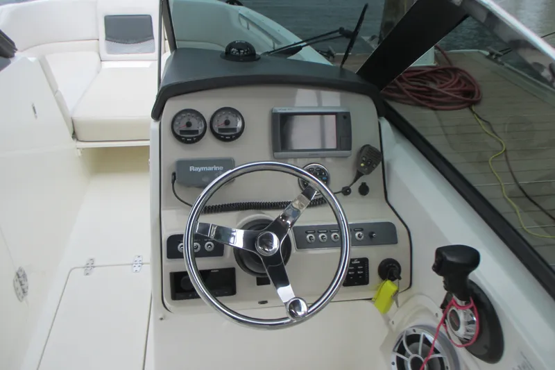 Slide: The Image of 2013 Boston Whaler 230 Vantage boat dashboard with steering wheel and navigation controls. - 11