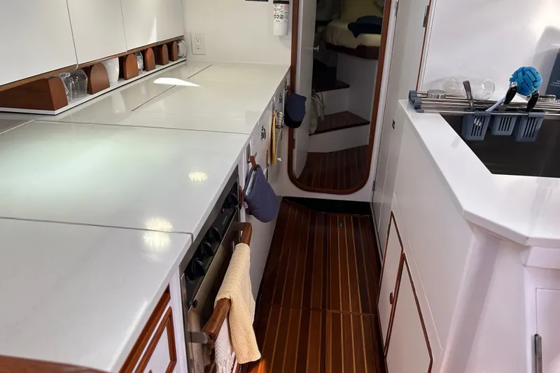 Slide: The Image of Interior of 1989 Hylas 44 yacht kitchen with sleek countertops and wooden flooring. - 28