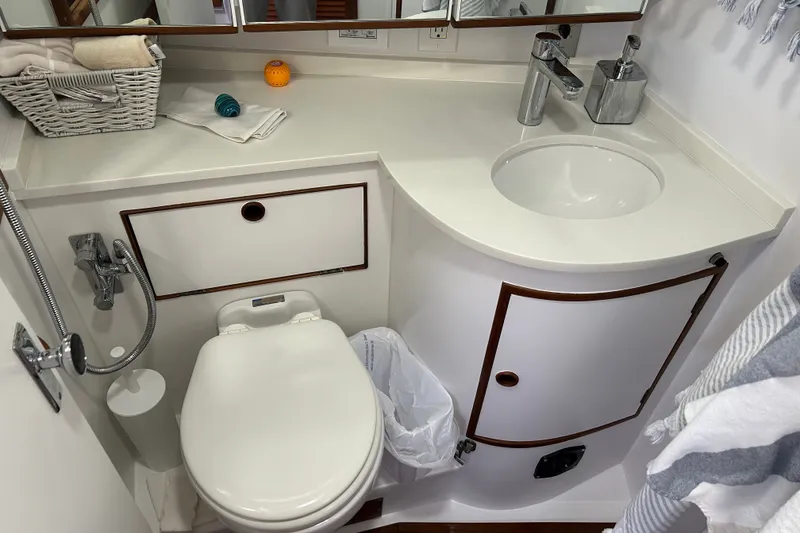 Slide: The Image of Compact bathroom in a 1989 Hylas 44 yacht with sink, toilet, and storage. - 34