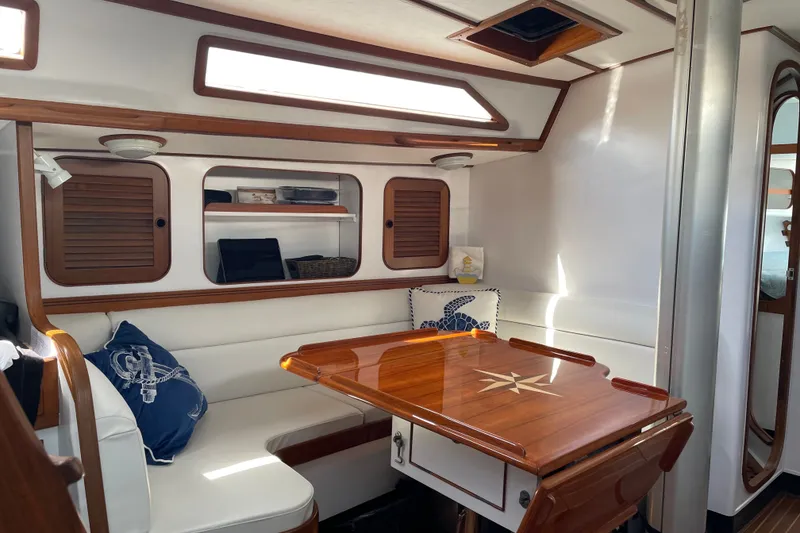 Slide: The Image of Interior of 1989 Hylas 44 yacht with wooden table and white seating. - 19