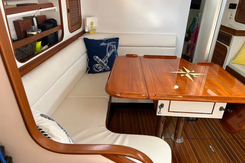 Slide: The Image of Interior of a 1989 Hylas 44 yacht with wooden table and cushioned seating. - 18