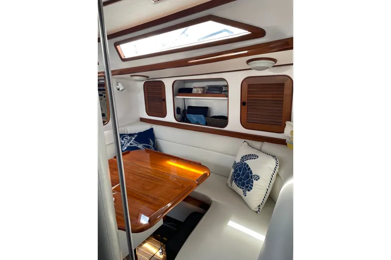 Slide: The Image of Interior of 1989 Hylas 44 yacht with wooden table and nautical-themed cushions. - 20