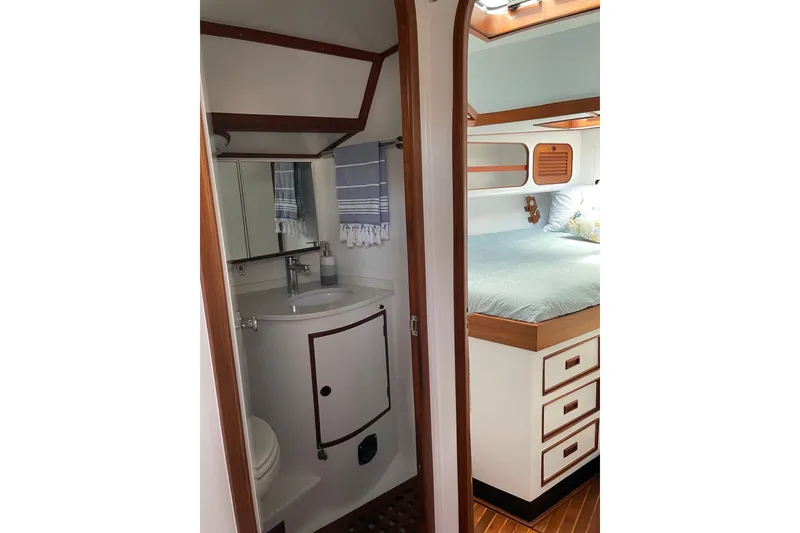 Slide: The Image of Interior of 1989 Hylas 44 yacht featuring a compact bathroom and cozy bedroom. - 37