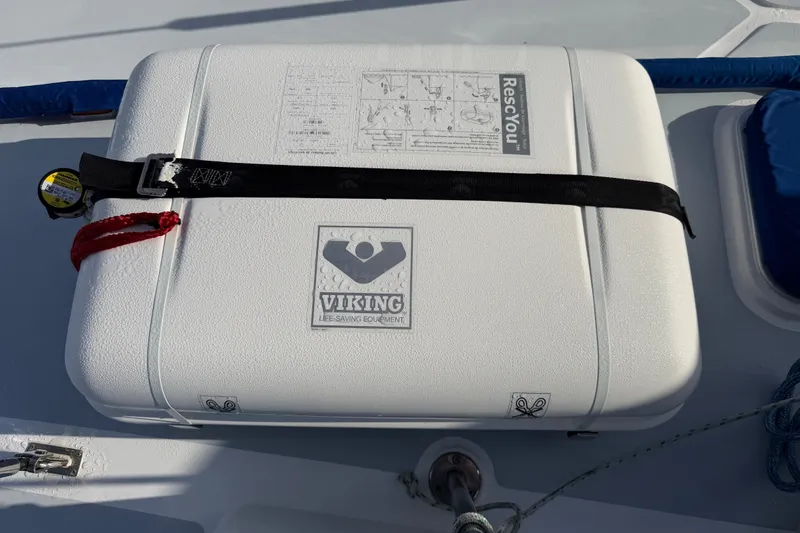 Slide: The Image of Liferaft on 1989 Hylas 44 sailboat deck, secured with straps. - 52