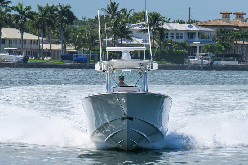 Slide: The Image of 2025 Valhalla Boatworks V-33 cruising on a sunny waterfront with palm trees. - 12