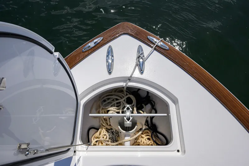 Slide: The Image of Valhalla Boatworks V-33 (2025) bow storage with ropes and anchor, on calm water. - 36