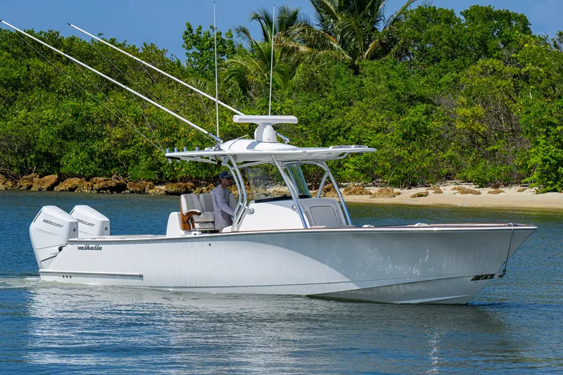 Slide: The Image of 2025 Valhalla Boatworks V-33 cruising near lush shoreline, featuring twin Mercury engines. - 3