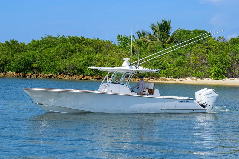 Slide: The Image of 2025 Valhalla Boatworks V-33 cruising on calm waters near a lush, green shoreline. - 4