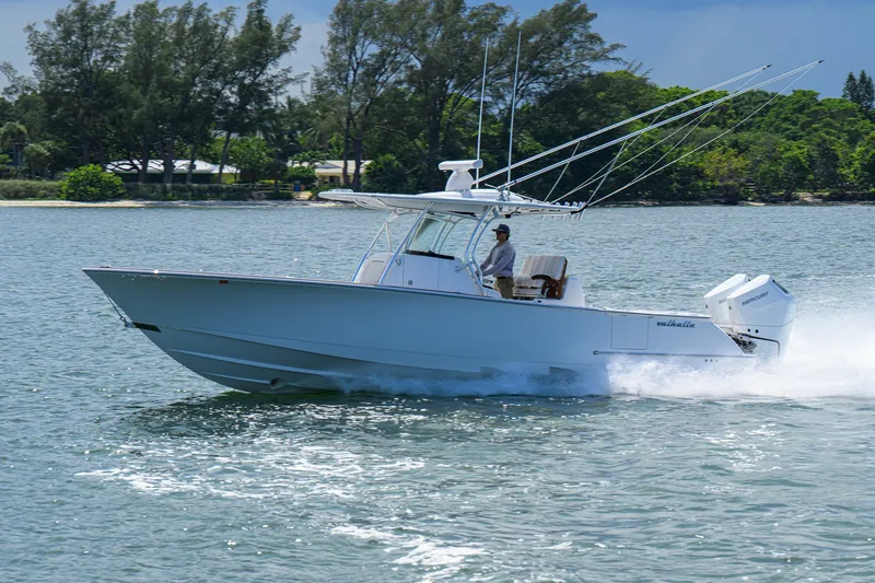 Slide: The Image of 2025 Valhalla Boatworks V-33 cruising on water, side view with lush greenery background. - 10