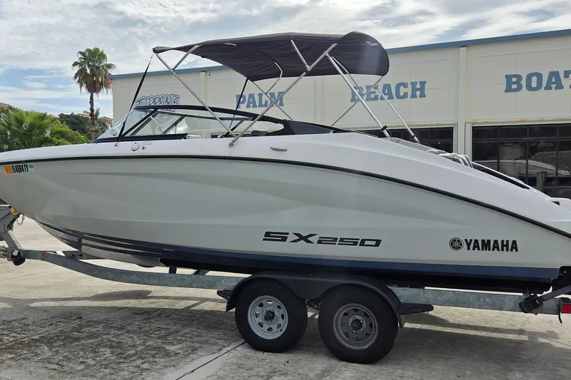 Slide: The Image of 2024 Yamaha SX250 boat on trailer at Palm Beach dealership. - 2