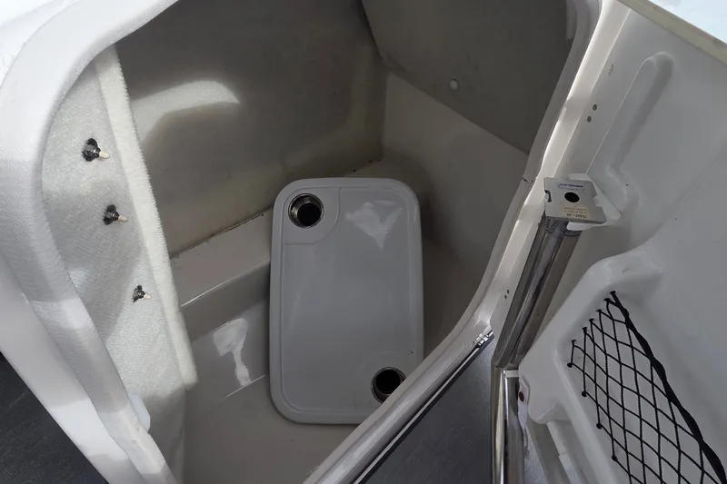Slide: The Image of 2024 Yamaha Boats SX250 storage compartment with removable tray and netted pocket. - 14