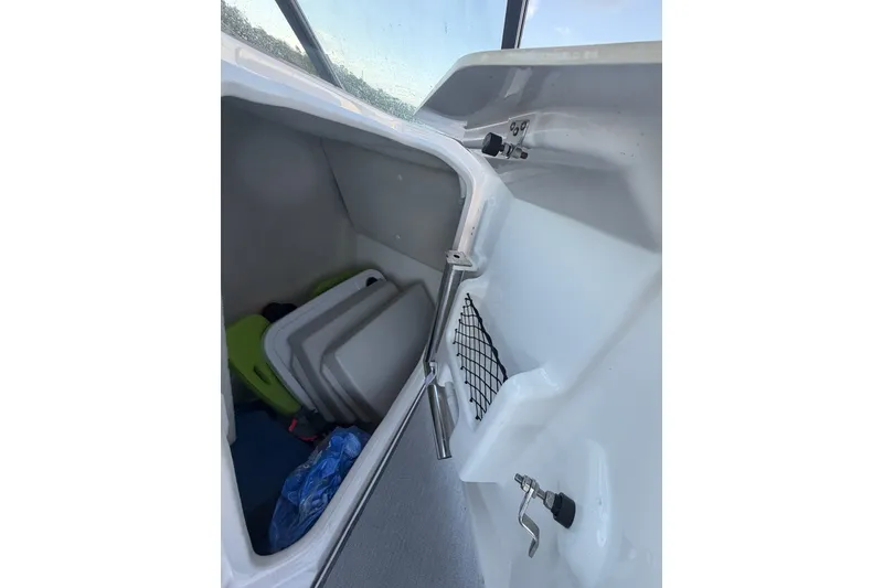 Slide: The Image of 2024 Yamaha Boats SX250 storage compartment with gear and accessories. - 10
