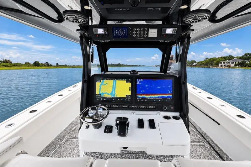 Slide: The Image of Cockpit view of 2023 Freeman 43 boat with advanced navigation systems on a serene waterway. - 12