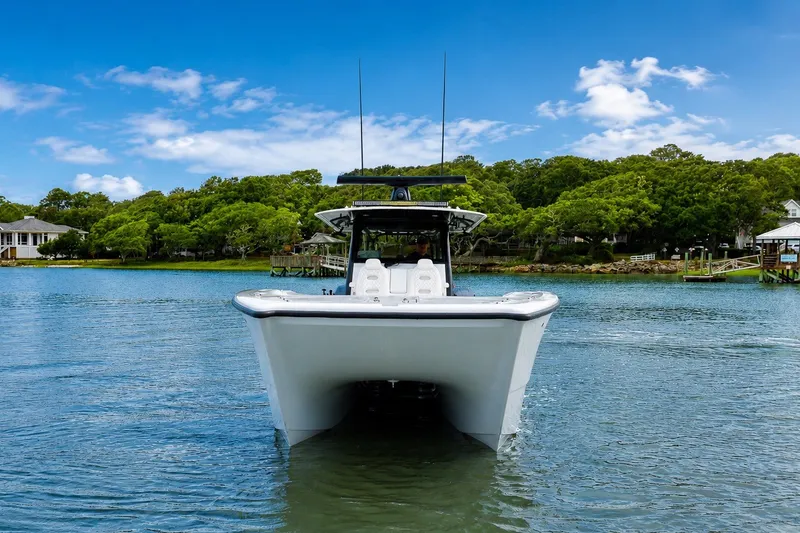 Slide: The Image of 2023 Freeman 43 boat on serene water with lush green shoreline. - 6