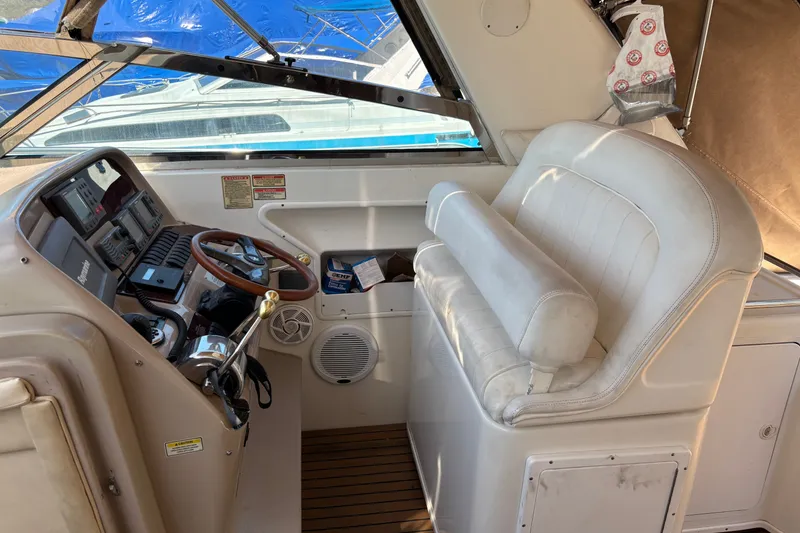 Slide: The Image of 2001 Sea Ray 340 Amberjack helm with white seating and wooden steering wheel. - 7