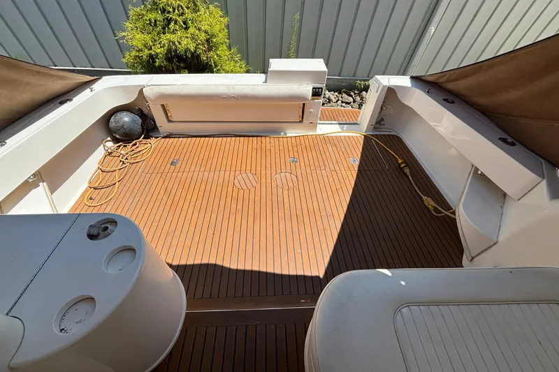 Slide: The Image of 2001 Sea Ray 340 Amberjack boat deck with wooden flooring and seating area. - 3