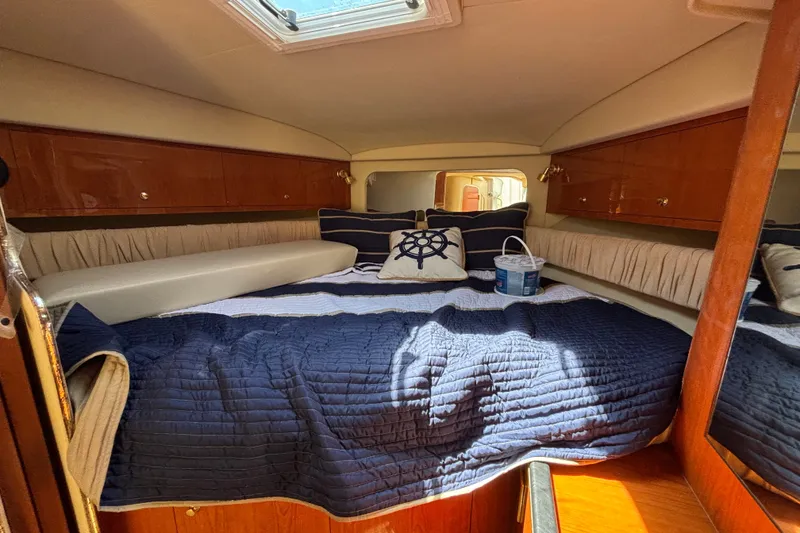 Slide: The Image of Cozy cabin interior of 2001 Sea Ray 340 Amberjack with nautical-themed bedding. - 12