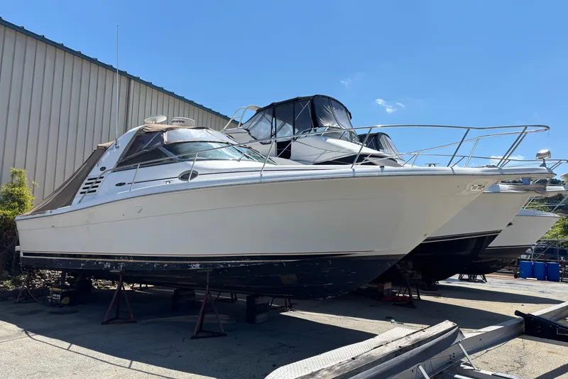The Image of 2001 Sea Ray 340 Amberjack boat on dry dock under clear blue sky. - 0