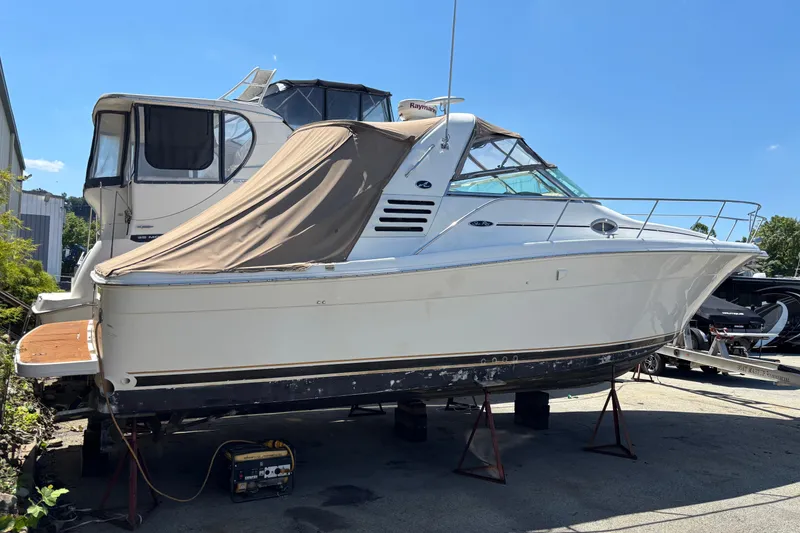 Slide: The Image of 2001 Sea Ray 340 Amberjack boat on stands, covered, in a marina setting. - 1