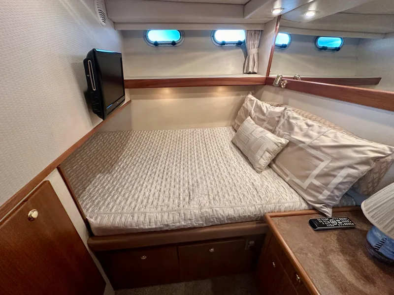 Slide: The Image of Cabin of the Bayliner 4788 Pilot House Motoryacht with a cozy bed and windows. - 47