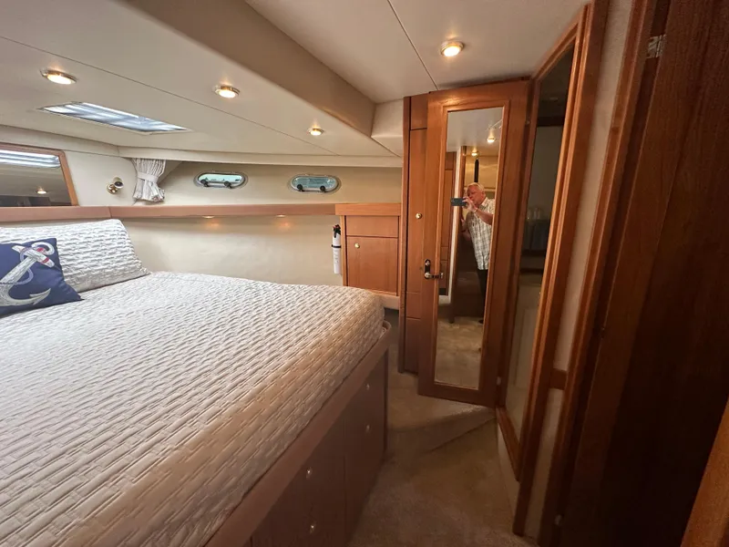 Slide: The Image of The image shows a cozy cabin with a large bed, wooden furnishings, and porthole windows. - 42