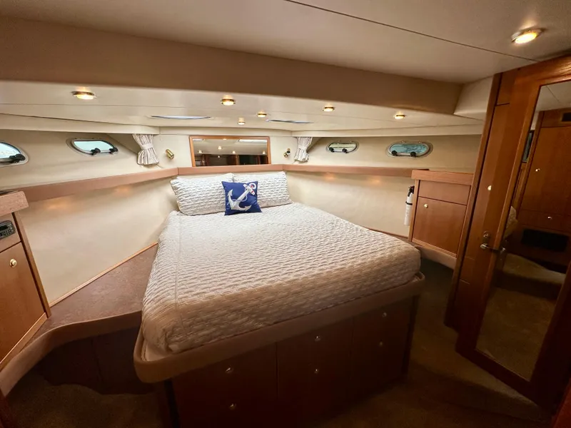 Slide: The Image of The image shows a cozy cabin with a large bed, wooden furnishings, and porthole windows. - 40