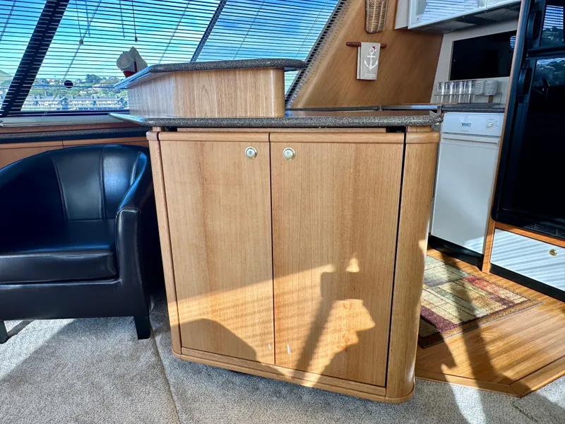 Slide: The Image of Interior of a 1999 Bayliner 4788 with wooden cabinetry and a black leather chair. - 26