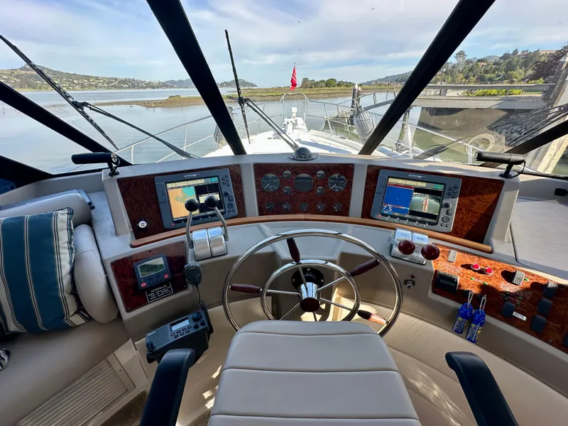 Slide: The Image of The image shows the helm of a 1999 Bayliner 4788 Pilot House Motoryacht with modern instruments. - 15