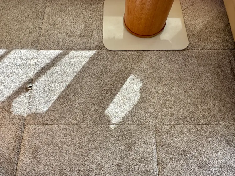 Slide: The Image of A carpeted floor with a wooden table leg in a boat, sunlight streaming through a window. - 25