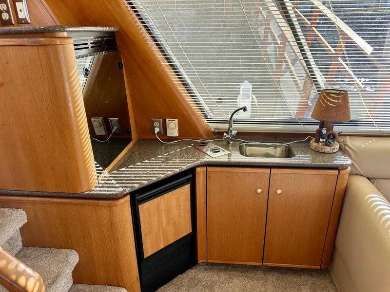 Slide: The Image of The 1999 Bayliner 4788's galley features a sink, cabinets, and a small window. - 35
