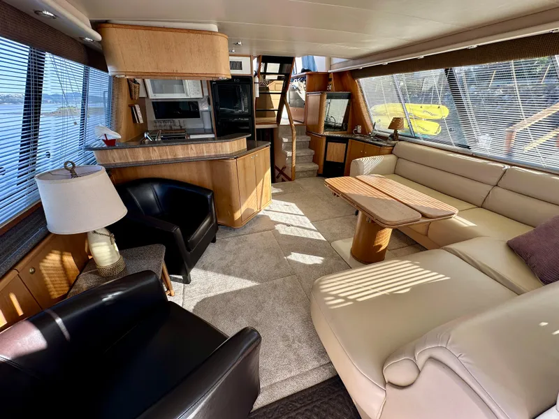 Slide: The Image of Interior of a 1999 Bayliner 4788 Pilot House Motoryacht featuring a cozy living area and kitchen. - 16