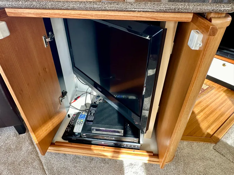 Slide: The Image of A TV and DVD player are installed in a wooden cabinet, surrounded by carpet flooring. - 27